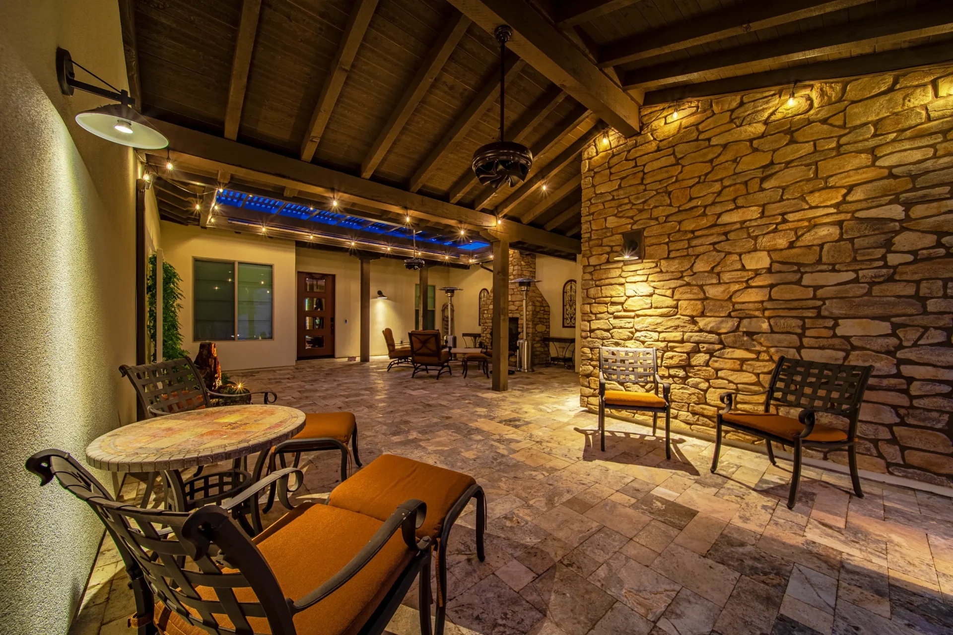 A big modern hall with rock walls and fireplace